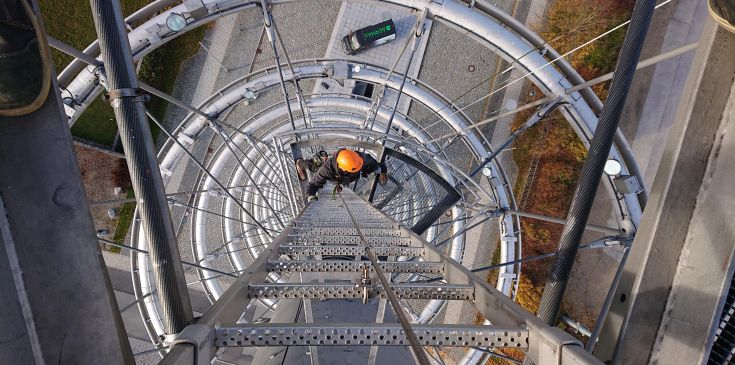 AERMAX Industriekletterer auf Steigleiter bei Höhenarbeiten am Messeturm München