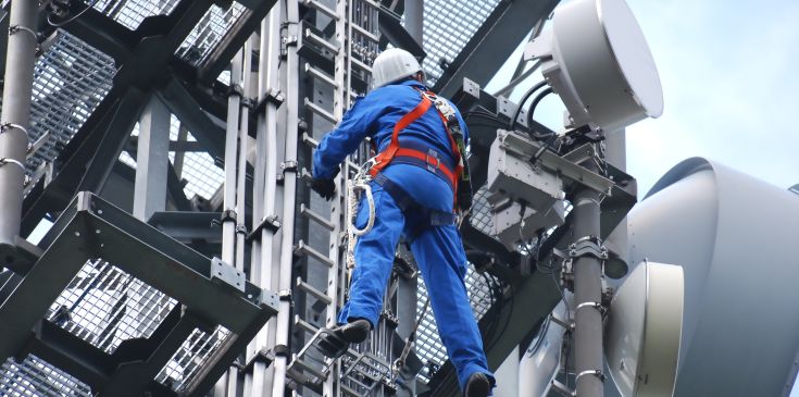 Höhenarbeiter bei Netzinstallation an Mast gesichert mit PSAgA