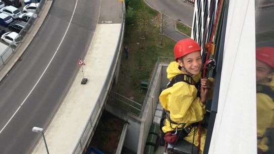 12-jähriger Lukas als Höhenarbeiter bei AERMAX an Fassade hängend